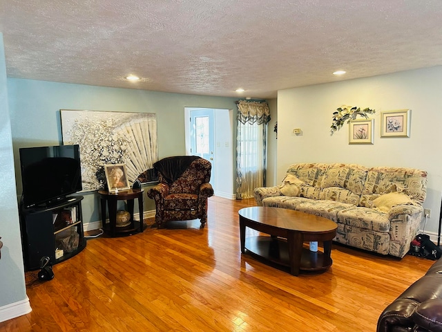 living room featuring wood-type flooring and a textured ceiling