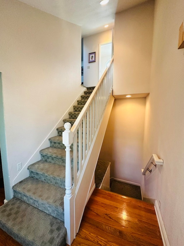 stairs featuring wood-type flooring