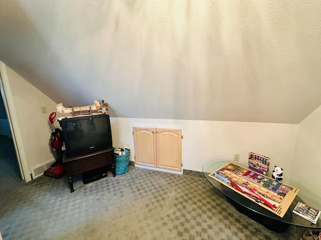 bonus room with a textured ceiling, lofted ceiling, and carpet