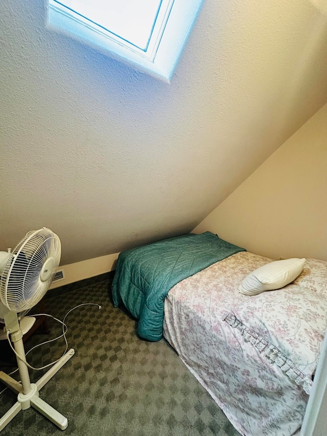 carpeted bedroom with lofted ceiling and a textured ceiling