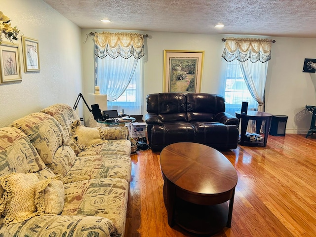 living room featuring hardwood / wood-style floors, a wealth of natural light, and a textured ceiling