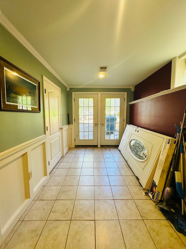 clothes washing area with washer / clothes dryer, french doors, light tile patterned floors, and crown molding