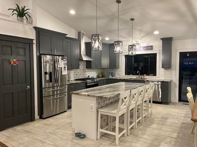 kitchen with pendant lighting, sink, a kitchen breakfast bar, a center island, and stainless steel appliances