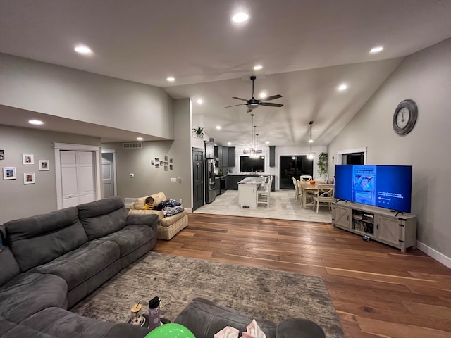 living room with ceiling fan, high vaulted ceiling, and hardwood / wood-style floors