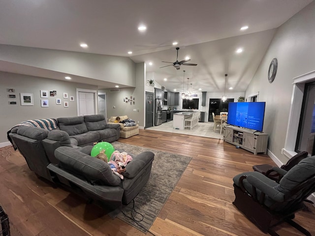 living room featuring wood-type flooring, ceiling fan, and high vaulted ceiling