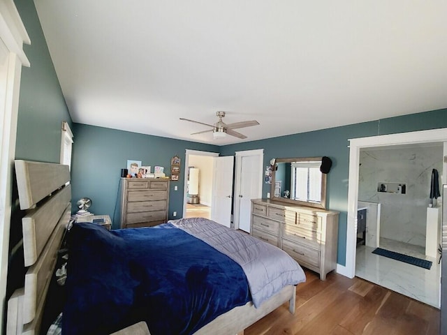 bedroom with dark hardwood / wood-style floors, ceiling fan, and ensuite bath