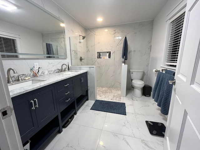 bathroom with vanity, toilet, tile walls, and a tile shower