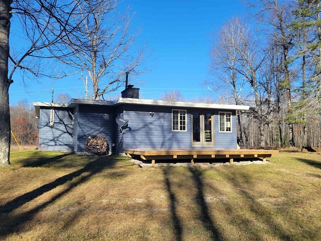 rear view of property featuring a lawn and a wooden deck