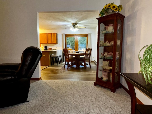 dining room featuring ceiling fan, light hardwood / wood-style floors, and a textured ceiling