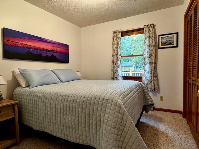 carpeted bedroom with a closet and a textured ceiling