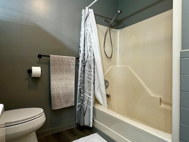 bathroom featuring toilet, hardwood / wood-style flooring, and shower / tub combo with curtain