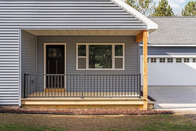 doorway to property featuring covered porch and a garage