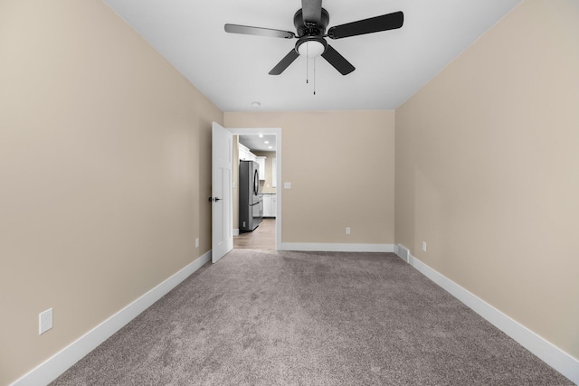 carpeted spare room with ceiling fan