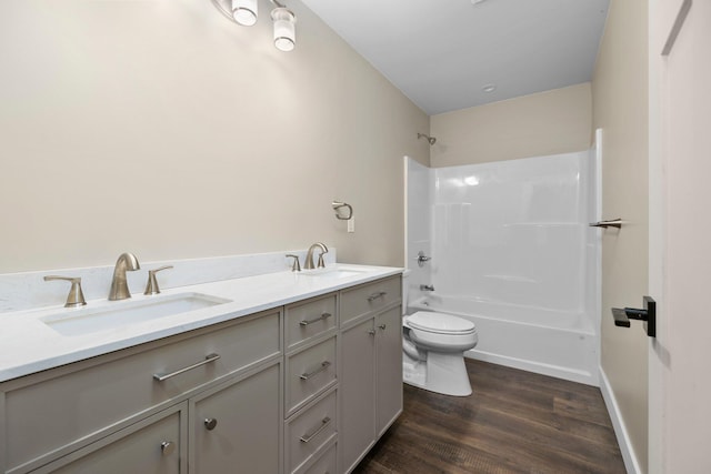 full bathroom with bathtub / shower combination, vanity, hardwood / wood-style flooring, and toilet