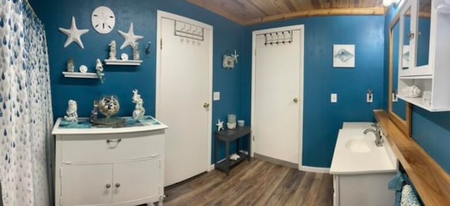 bathroom featuring hardwood / wood-style floors, wood ceiling, and sink