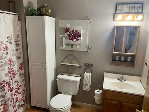 bathroom featuring vanity, hardwood / wood-style flooring, toilet, and curtained shower