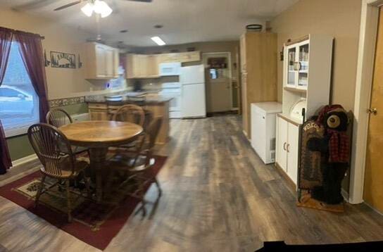 dining space with ceiling fan and dark wood-type flooring