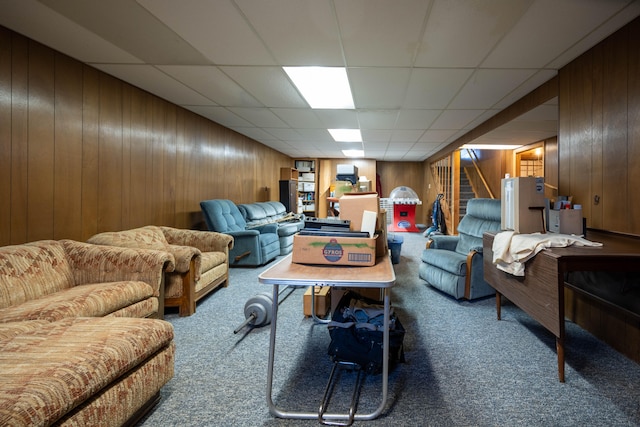 carpeted living room with a paneled ceiling and wooden walls