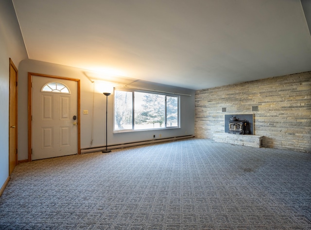 unfurnished living room featuring baseboard heating and a wood stove