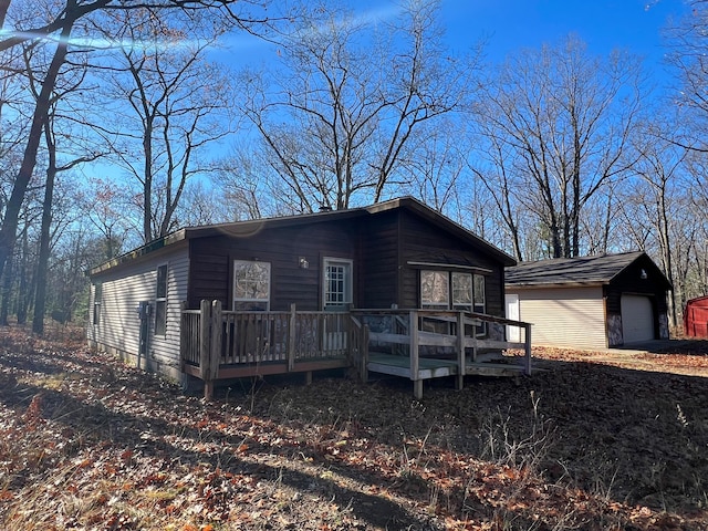 view of front of home featuring a wooden deck, an outbuilding, and a garage