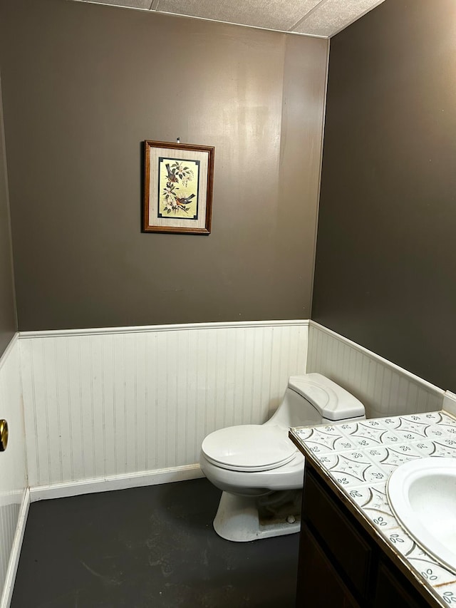 bathroom with vanity, a textured ceiling, concrete floors, and toilet