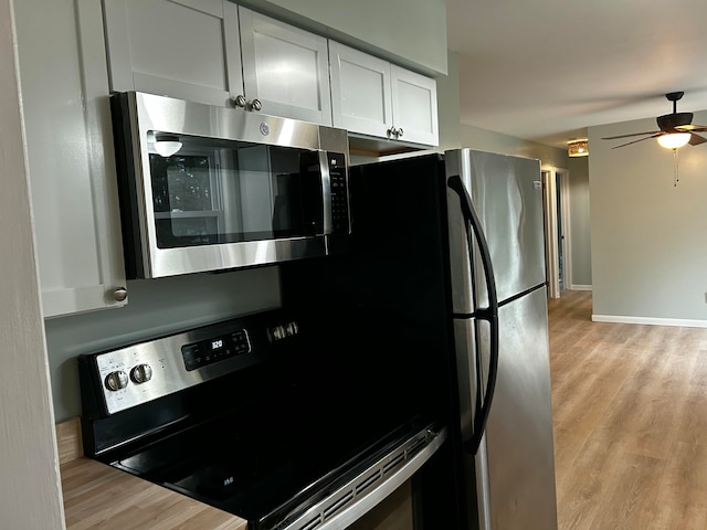 kitchen featuring white cabinets, ceiling fan, light hardwood / wood-style floors, and black electric range