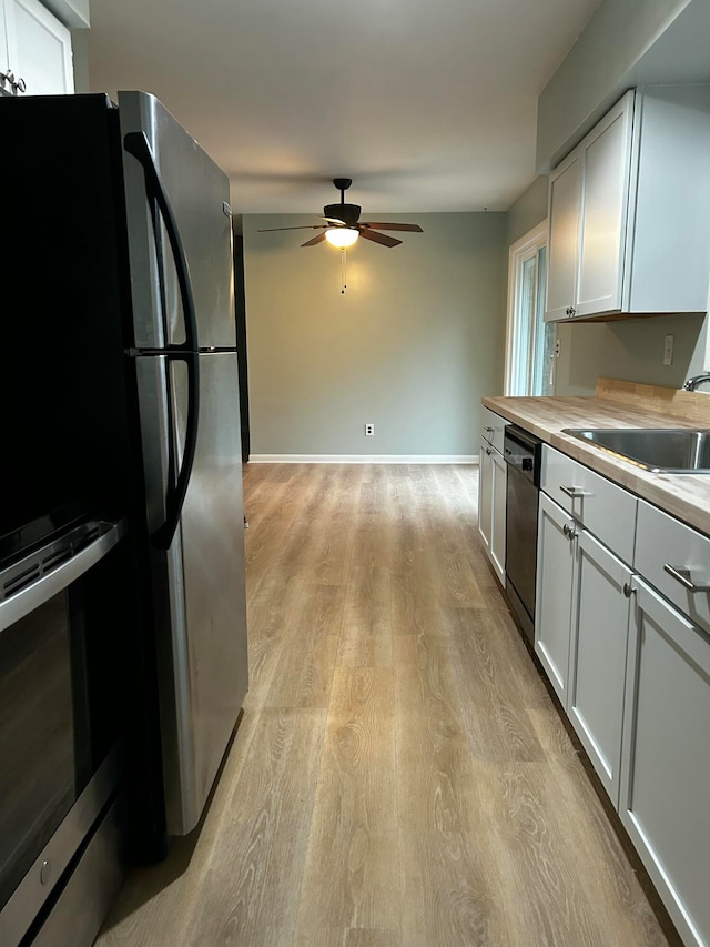 kitchen with white cabinets, appliances with stainless steel finishes, and light wood-type flooring