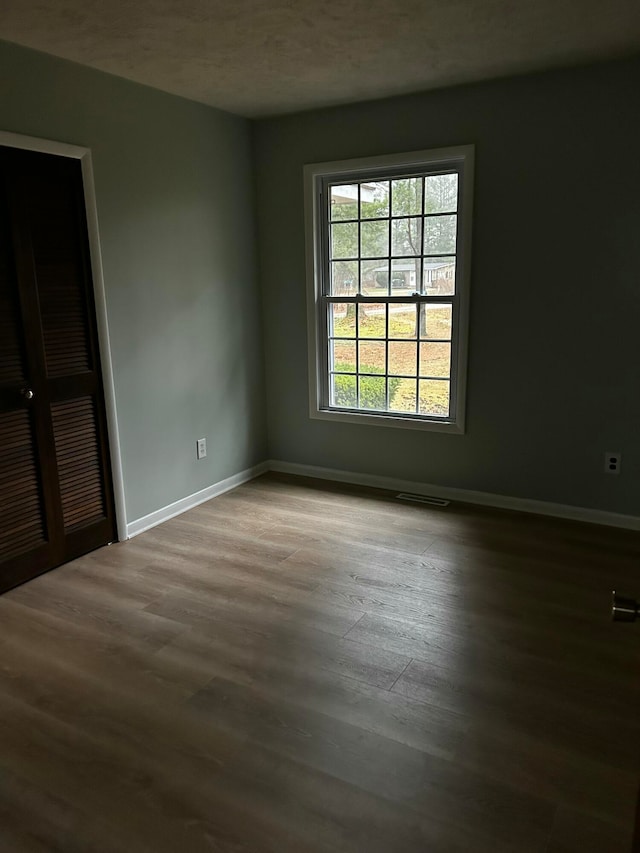 spare room featuring hardwood / wood-style floors and a textured ceiling