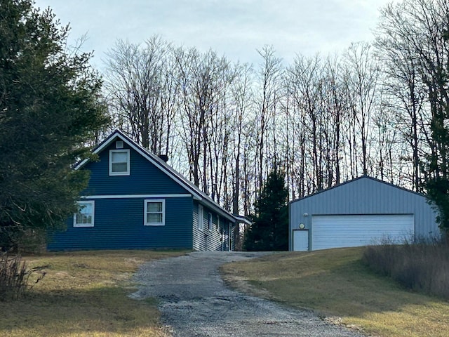 view of side of property featuring a lawn, a garage, and an outdoor structure