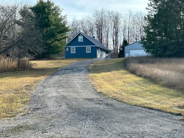 view of side of home featuring a garage and an outbuilding