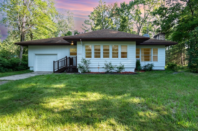 view of front of house with a garage and a lawn