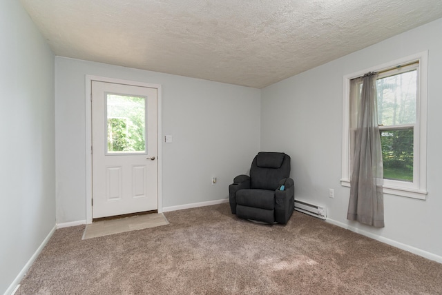 unfurnished room with carpet floors, a textured ceiling, and a baseboard heating unit