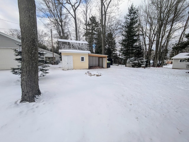 yard layered in snow with a storage shed