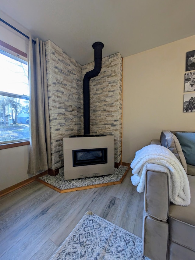 unfurnished living room with a wood stove and wood-type flooring