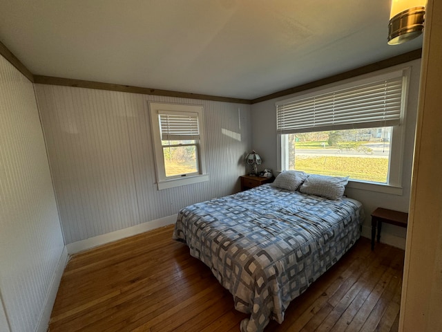 bedroom with dark hardwood / wood-style flooring and ornamental molding