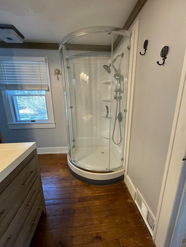 bathroom featuring vanity, hardwood / wood-style flooring, and walk in shower