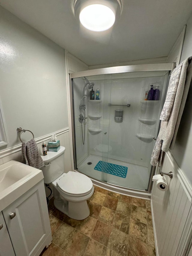 bathroom with vanity, toilet, and an enclosed shower