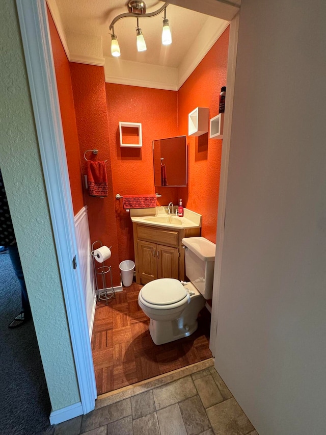 bathroom with vanity, toilet, and ornamental molding