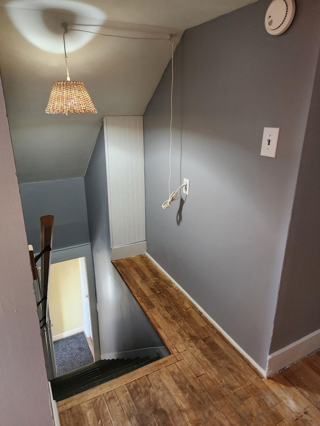 stairs featuring vaulted ceiling and hardwood / wood-style flooring