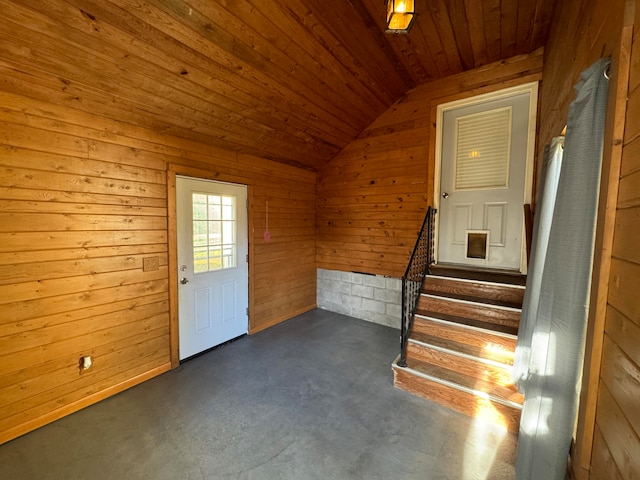 doorway to outside with wooden walls, lofted ceiling, and wood ceiling