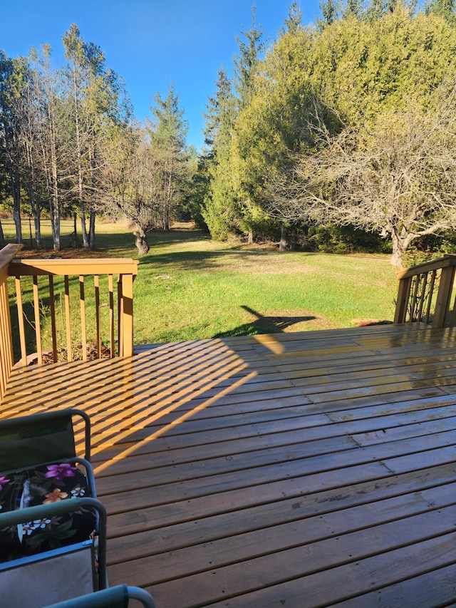 wooden deck featuring a lawn