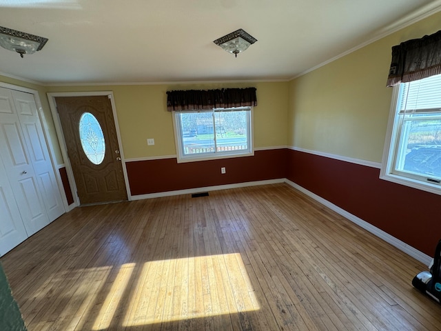 foyer with hardwood / wood-style floors and crown molding