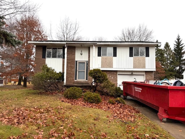 split foyer home with a front yard and a garage