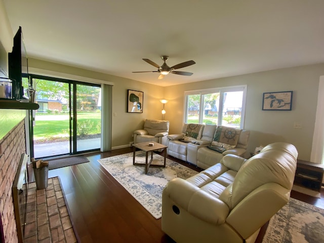 living room with ceiling fan, dark wood-type flooring, and a healthy amount of sunlight