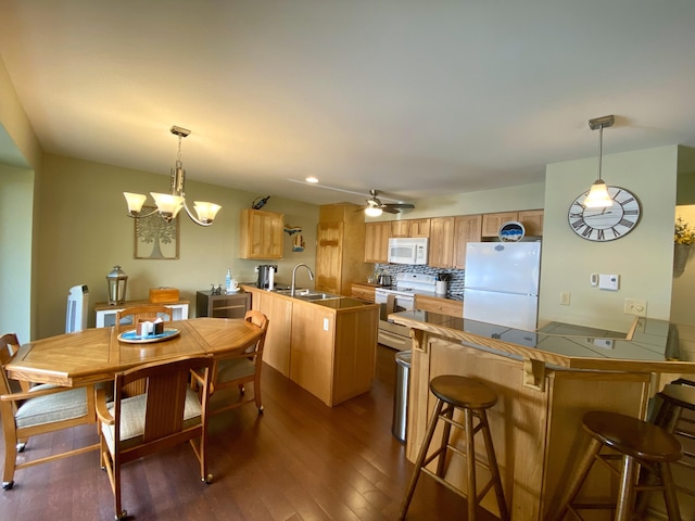 dining room featuring dark hardwood / wood-style floors, sink, and ceiling fan with notable chandelier