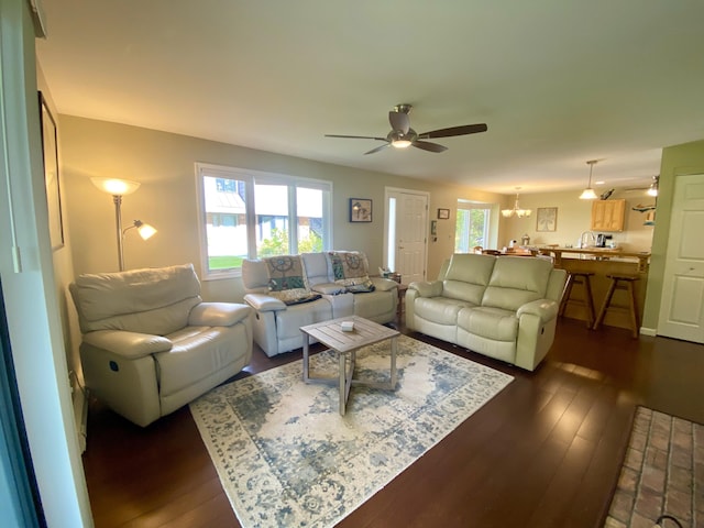 living room featuring dark hardwood / wood-style floors and ceiling fan with notable chandelier