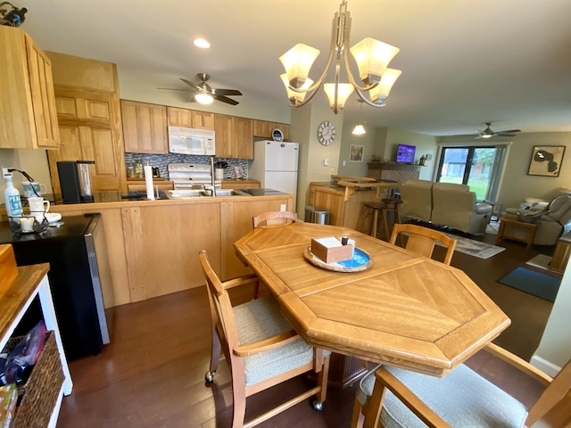 dining area featuring ceiling fan with notable chandelier and dark hardwood / wood-style flooring