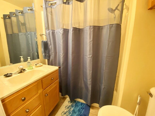 bathroom with curtained shower, tile patterned flooring, vanity, and toilet