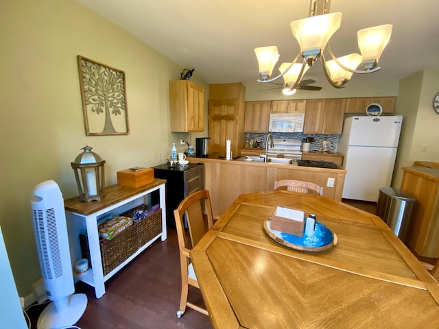 dining area featuring dark wood-type flooring, a notable chandelier, and sink