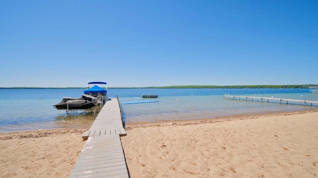 dock area featuring a beach view and a water view